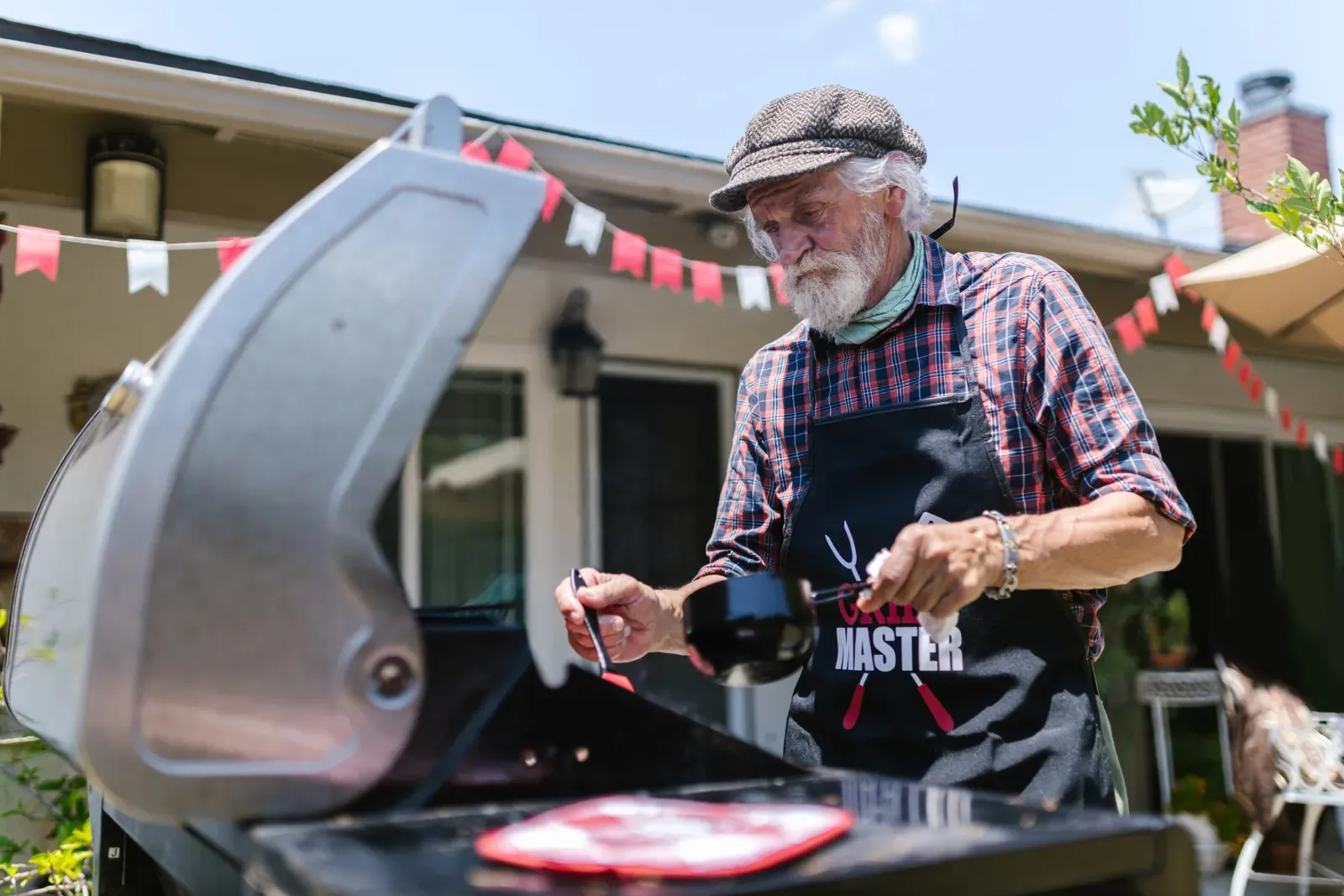 A backyard cook checking meat on the grill, thermometer technique in action
